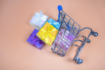 Shopping carts with gifts inside on a beige background.
