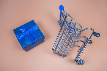 Shopping carts with gifts inside on a beige background.