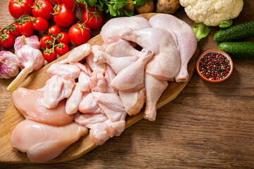 fresh chicken meat with vegetables on a wooden table