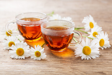cups of herbal chamomile tea with fresh chamomile flowers