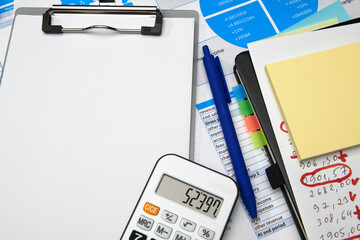 business office desk closeup - financial reports, analysis and accounting, set of documents, tables and graphs, various items for bookkeeping, calculator