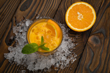 Cocktail. Orange juice with mint and ice rustic wooden table