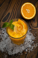 Cocktail. Orange juice with mint and ice rustic wooden table