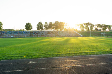 football stadium . Stadium with green grass at sunset , sunrise