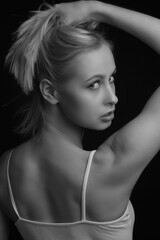 black-and-white portrait of a blonde on a black background.