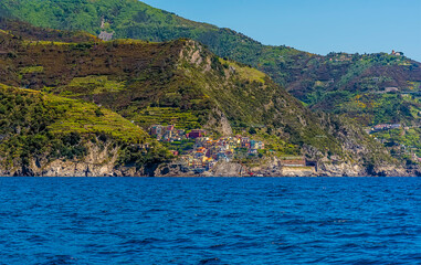 Fototapeta premium A view along the Cinque Terre coastline towards the village of Manarola, Italy in the summertime