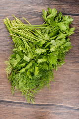 Top view. Bunch of parsley and dill on wooden table.