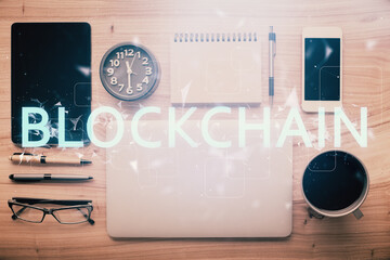 Double exposure of blockchain theme hologram over table with phone. Top view. Crypto technology...