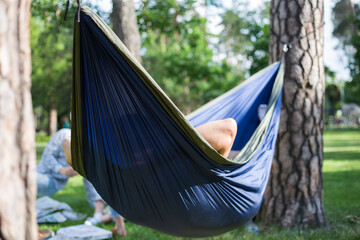 Young guy has a rest in summer in a hammock
