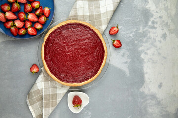 Strawberry cake with fresh berries on grey concrete background, top view, copy space