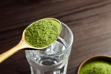 Spoon with freeze dried wheatgrass powder for wheatgrass detox juice.