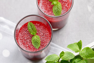 Strawberry homemade mousse dessert with fresh mint leaves on grey concrete background