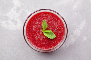 Strawberry mousse dessert with fresh mint leaves on grey concrete background