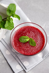 Homemade strawberry mousse dessert with fresh mint leaves on grey linen napkin