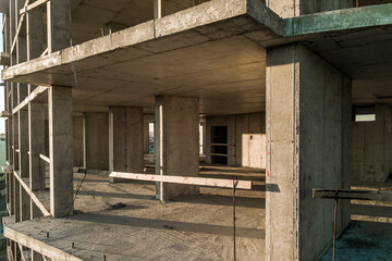 Obraz premium Aerial view of concrete frame of tall apartment building under construction in a city.