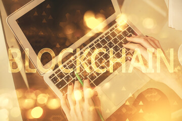 Double exposure of woman hands working on computer and blockchain theme hologram drawing. Top View. bitcoin cryptocurrency concept.