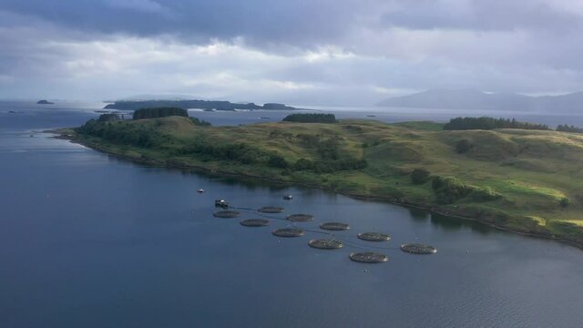 Aerial footage of the sound of shuna and shuna island on the west coast of the argyll region of the highlands of Scotland during a summer storm showing a salmon fish farm
