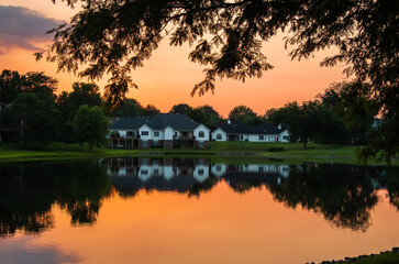 Beautiful view of sunset over Midwestern  suburban neighborhood  by a lake