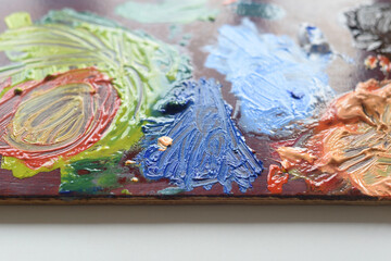 Artist's palette with multi-colored paints close up.
