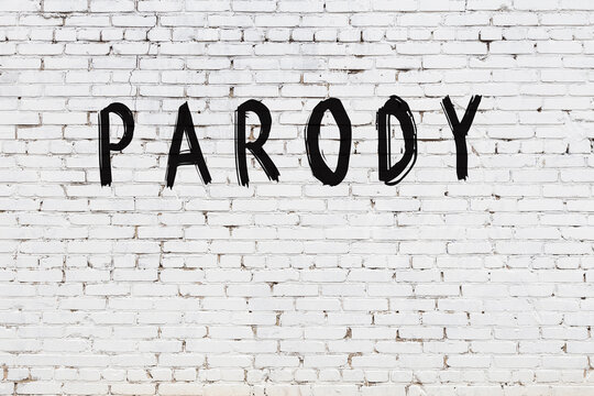 White wall with black paint inscription parody on it