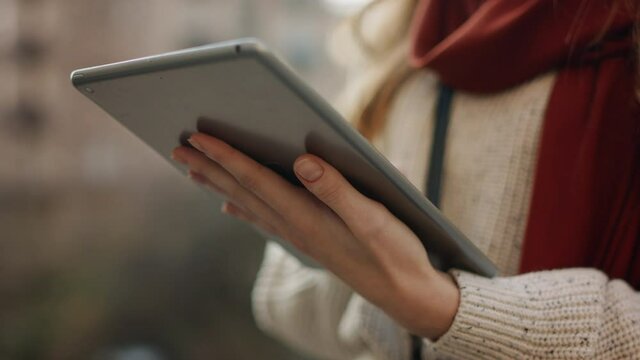 Closeup woman hands serfing internet on tablet computer outdoors.