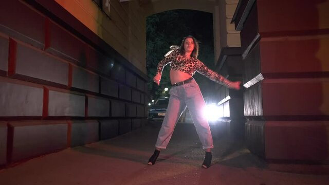 young dancer performs modern choreography, street dance in the arch at night. Urban dancing freestyle in the city. Gimbal shot