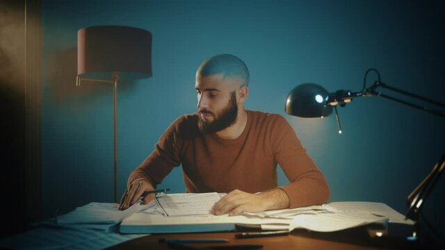 Man writing musical notes at a desk
