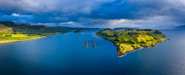 Aerial view of the sound of shuna and shuna island on the west coast of the argyll region of the highlands of Scotland during a summer storm showing a salmon fish farm