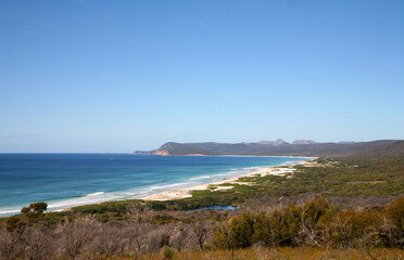 Coastline of Tasmania, Australia featuring dunes, sand, foliage and beautiful blue skies