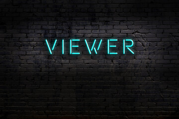 Neon sign. Word viewer against brick wall. Night view