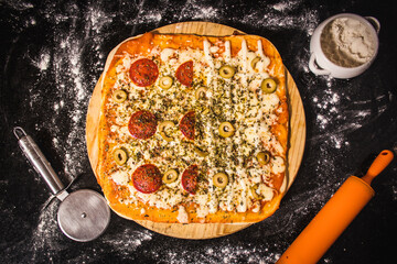 pizza with cheese and tomatoes on a wooden board