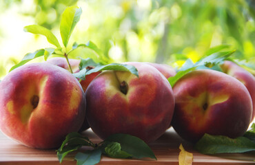 Ripe peaches and leaves on table