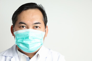 Close-up Asian man looks self-confident wearing a white shirt, wearing a medical mask to prevent the virus, looking at the camera isolated on a white background. With copy space on the right-hand side