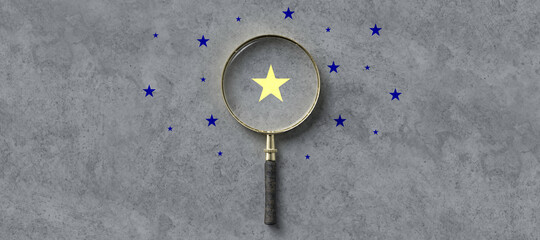 magnifying glass with a yellow star mark as symbol for finding a solution on concrete background