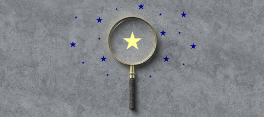 magnifying glass with a yellow star mark as symbol for finding a solution on concrete background