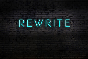 Neon sign. Word rewrite against brick wall. Night view
