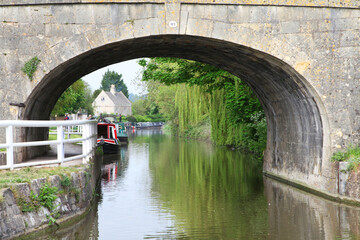 Fototapeta premium Beautiful canal in United Kingdom, featuring trees, water and boats