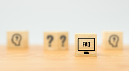 cubes with text FAQ on wooden surface and white background