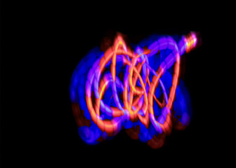 light painting abstract background. curves and waves of purple and red light against a black background