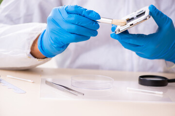 Male expert criminologist working in the lab for evidence