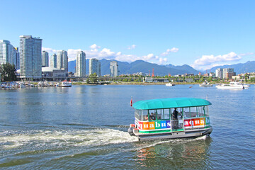 Olympic Village - Aqua Bus in Vancouver, BC. The view on the public transport boat with passengers...