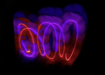 light painting abstract background. curves and waves of purple and red light against a black background