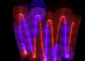 light painting abstract background. curves and waves of purple and red light against a black background