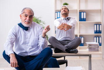 Obraz premium Two male employees working in the office