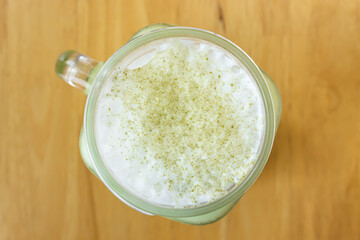 Cold Matcha Green Tea Beverage and Frothing Milk and Green Tea Powder Topping in Top View