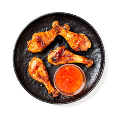 Roasted spicy chicken legs with chili sauce isolated on white background.