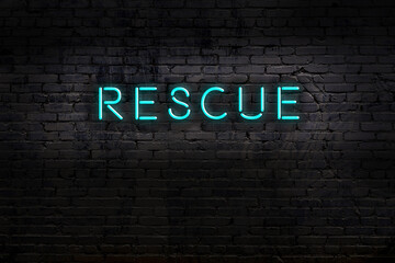 Night view of neon sign on brick wall with inscription rescue