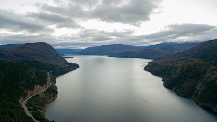 The lake at sunset. Aerial view of the lake, forest, mountains, and road at nightfall. 