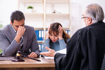 Young woman in courthouse with judge and lawyer