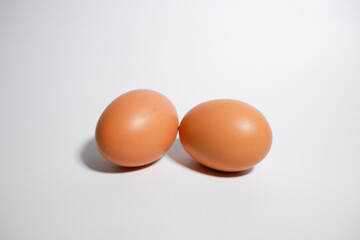 Two eggs that layed down on a white background (side view)